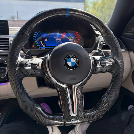 BMW carbon fibre flat bottom steering wheel, detail view of carbon trim and leather